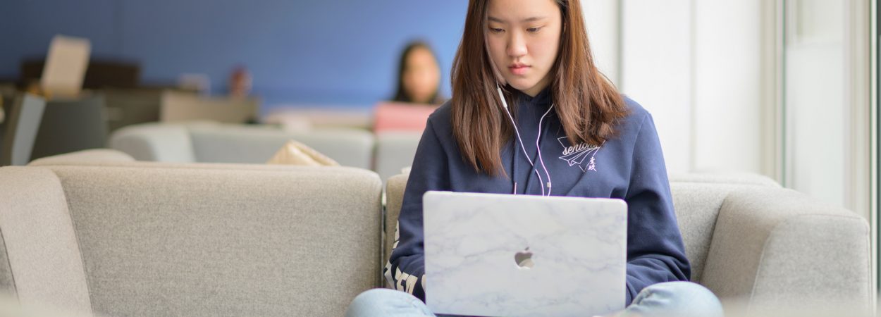 Female student, studying online, in a common space